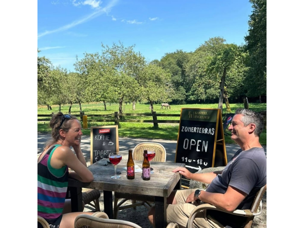 een man en een vrouw aan tafel met drank op ons zomerterras